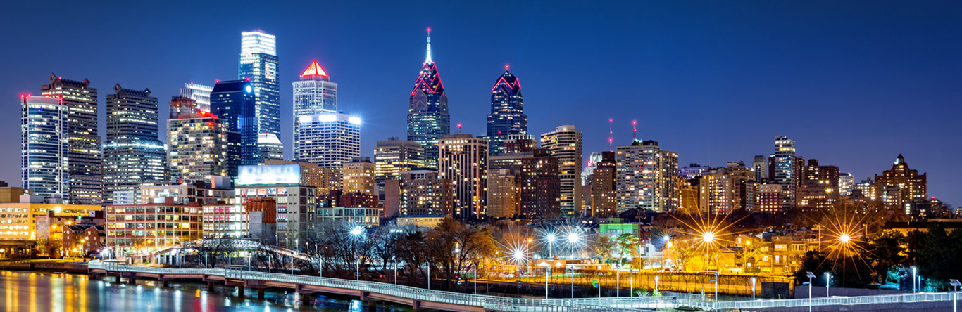 city skyline at night along river